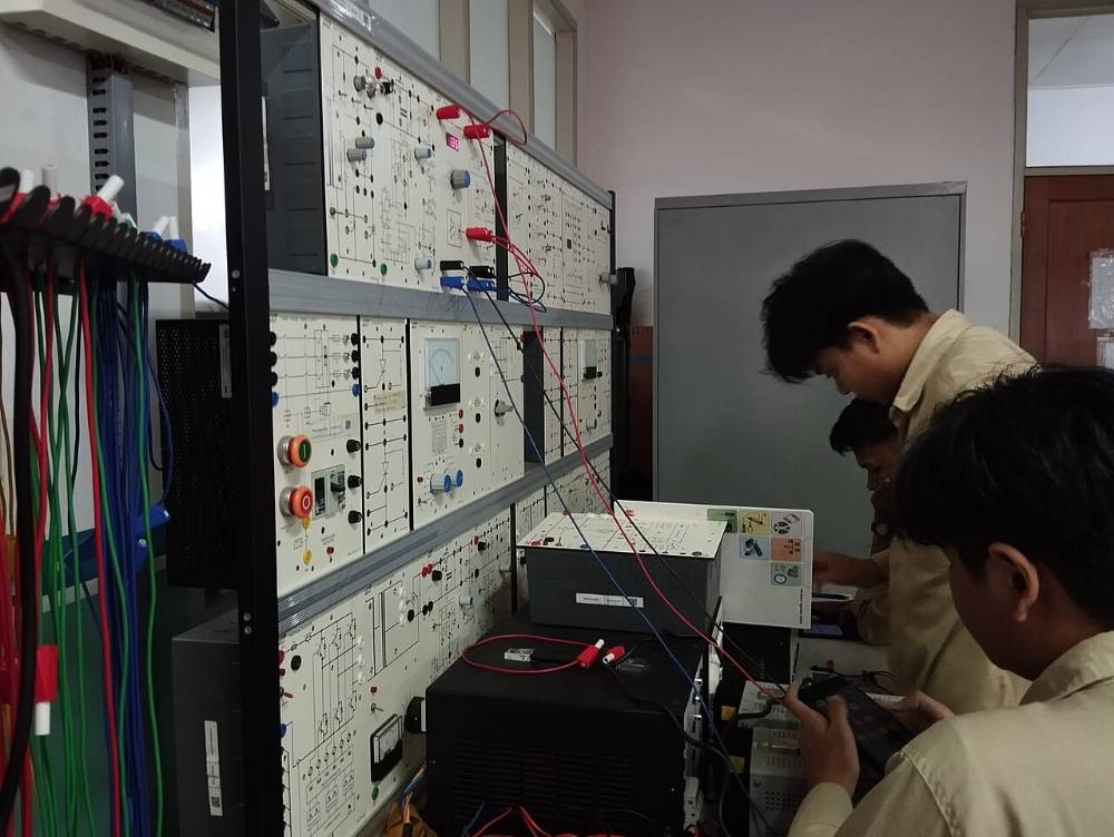 Students at an electrical practice panel in a polytechnic lab